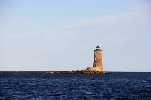 istock lighthouse by the sea at sunset 1028815966