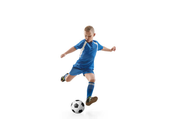 kleiner junge mit fußball fliegenden kick zu tun - child lifestyles isolated blue stock-fotos und bilder