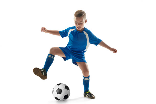 istock Young boy with soccer ball doing flying kick 1028821382