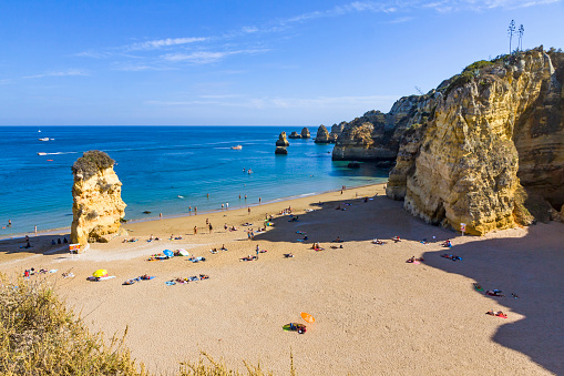 Lagos: Praia da Dona Ana beach, Lagos, Algarve region, Portugal. Praia Dona Ana surrounded by steep colourful strata cliffs. One of the most picturesque beaches in Algarve. One of the best beach of Portugal