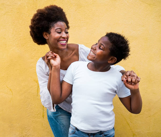 happy young mother having fun with her child - mom playing and dancing with his son - family lifestyle, motherhood, love and tender moments concept - focus on mum face - child caribbean black latin american and hispanic ethnicity imagens e fotografias de stock