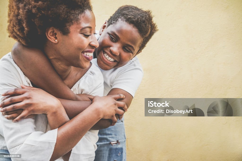 Glückliche junge Mutter Spaß mit ihrem Kind - Sohn umarmt seine Mutter im freien - Familie Lebensstil, Mutterschaft, Liebe und zärtliche Momente Konzept - Kind im Mittelpunkt stehen - Lizenzfrei Familie Stock-Foto