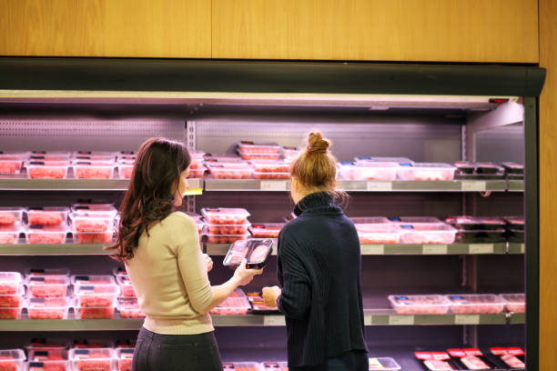 mujer compra un paquete de carne en el supermercado - supermarket meat women packaging fotografías e imágenes de stock