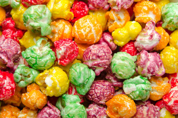 Multicolored popcorn scattered on pile. Background, close up
