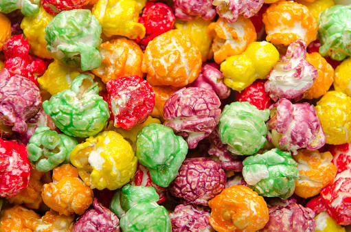 Multicolored popcorn scattered on a pile. Background, close up.