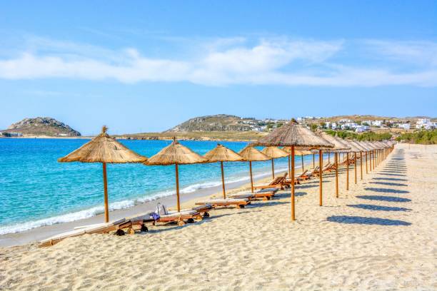 la plage de sable près de la mer bleue avec transats et parasols. mykonos - parasol umbrella sun beach photos et images de collection