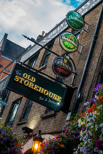 Dublin, Ireland - July 29, 2018: Beer signs over an entrance to a pub in the Temple Bar area in Dublin. It is a famous quarter with many pubs and restaurants.