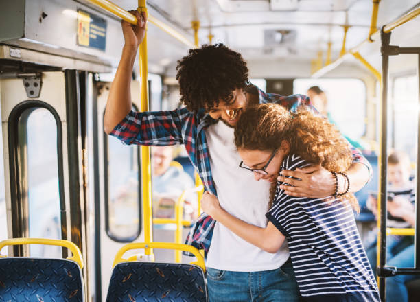 istock Happy multicultural young couple holding for a bar in a bus. 1028866894