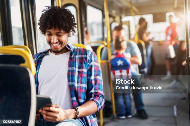 Happy Handsome Afroamerican Man Sitting In A Bus And Listening To The Music Stock Photo - Download Image Now