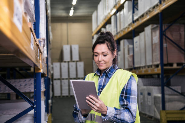 istock Female in warehouse on her digital tablet 1028869340