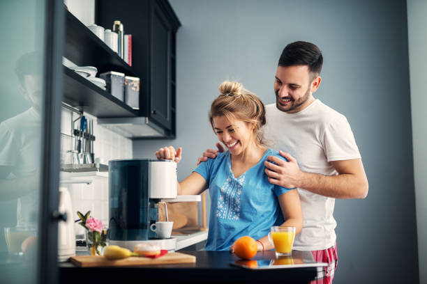 istock Happy in love young couple making some coffee in their kitchen. 1028872688