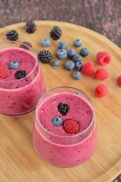 istock Raspberry blackberry blueberry smoothie on wooden board 1028872708
