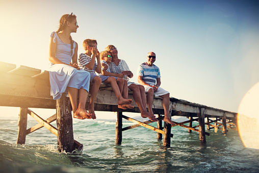 Family sitting on pier by the sea