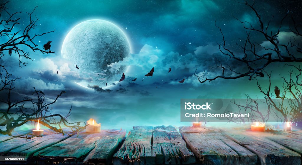 Sfondo Halloween - Vecchio tavolo con candele e rami nella notte spettrale con luna piena - Foto stock royalty-free di Halloween