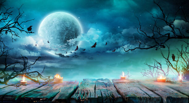 Halloween Background  - Old Table With Candles And Branches At Spooky Night With Full Moon Halloween Background  - Wooden Table With Candles At Spooky Night With Full Moon bat animal photos stock pictures, royalty-free photos & images
