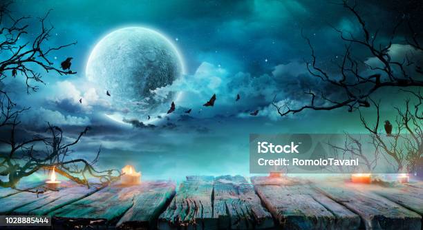 Halloween Background Old Table With Candles And Branches At Spooky Night With Full Moon Stock Photo - Download Image Now