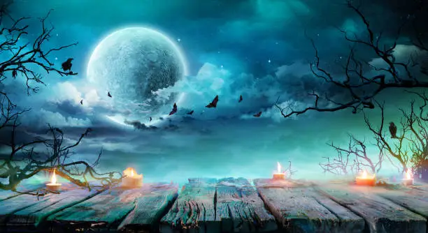 Photo of Halloween Background  - Old Table With Candles And Branches At Spooky Night With Full Moon