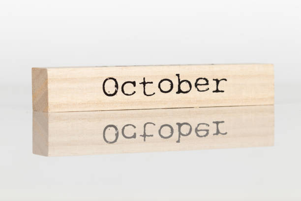 istock wooden cube with an inscription October on a white background 1028885600