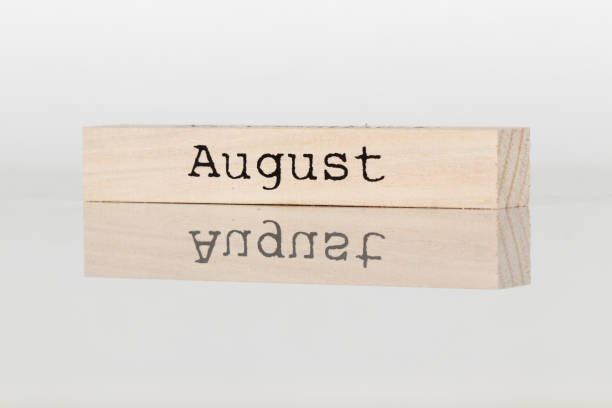 istock a wooden cube with the inscription August on a white background 1028885914