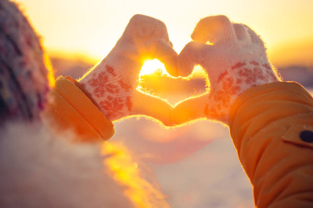 mani donna in guanti invernali simbolo del cuore - innevato immagine foto e immagini stock