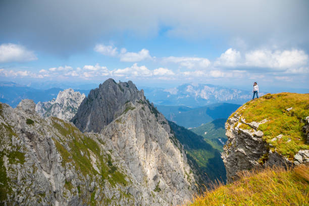 istock Young woman on cliff in Mangart saddle, Slovenia 1028896080