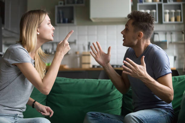 Angry millennial couple arguing shouting blaming each other of problems Angry millennial couple arguing shouting blaming each other of problem, frustrated husband and annoyed wife quarreling about bad marriage relationships, unhappy young family fighting at home concept confrontation stock pictures, royalty-free photos & images