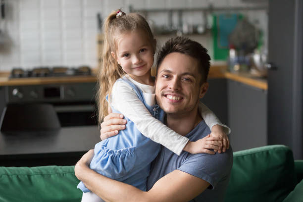 portrait de papa heureux hugging fille enfant regardant la caméra - oncle photos et images de collection