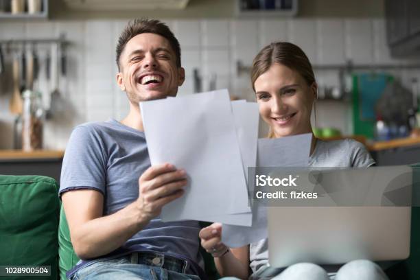 Happy Couple Laughing Having Fun With Documents And Laptop - Fotografias de stock e mais imagens de Conta - Acessório Financeiro