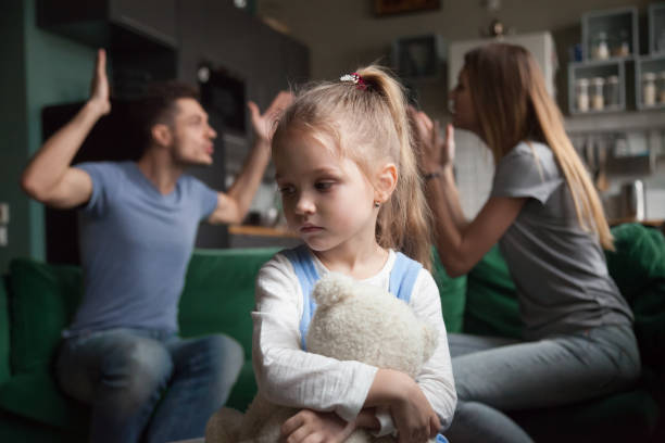 istock Kid daughter feeling upset while parents fighting at background 1028900516