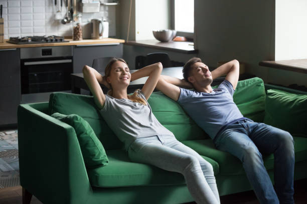 istock Happy couple leaning on sofa together, stress free weekend concept 1028900558