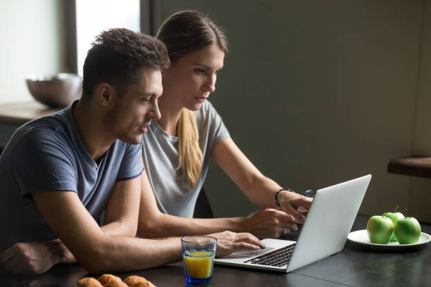 istock Couple using laptop for reading news or work having breakfast 1028900592