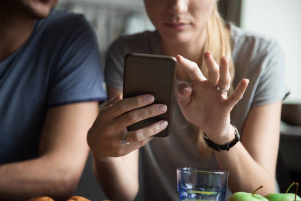 Couple customers holding mobile phone using smartphone apps, close up