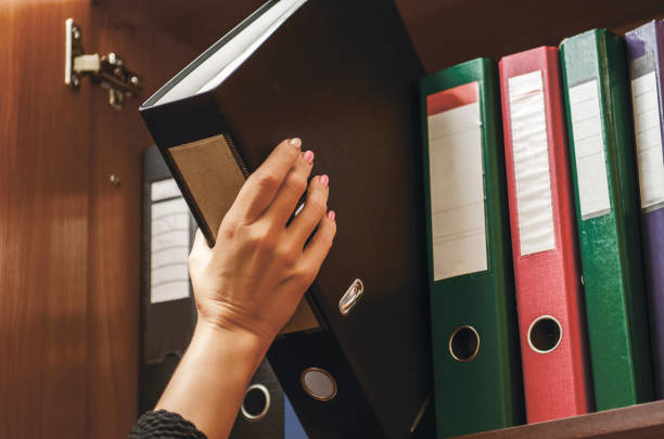 un officier femme choisir une reliure de document - pile arrangement photos photos et images de collection