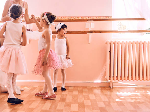 istock group of young ballerinas relaxing after exercising 1028904094