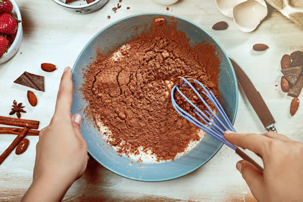 istock Cropped image of attractive young woman cooking a chocolate pie. Ingridients on white rustik background. Eggs, chocolate, milk, spices. 1028907032
