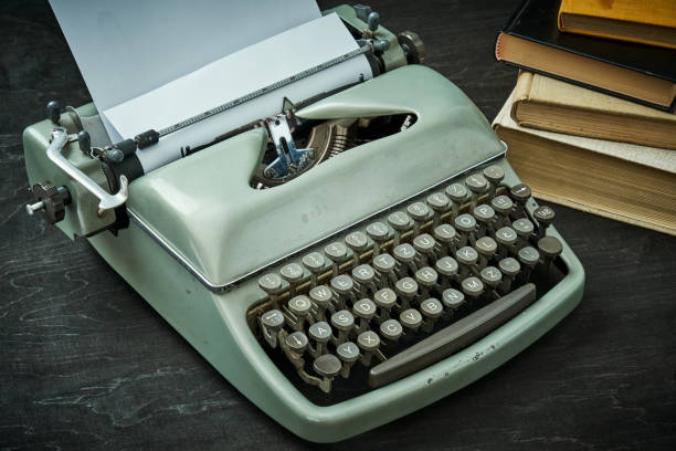 istock beautiful old gray typewriter and book on a black table 1028907684