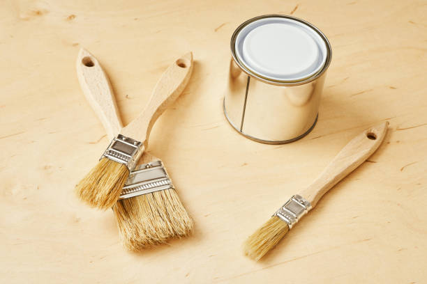 istock three brushes and a silver paint can on a wooden board 1028910106