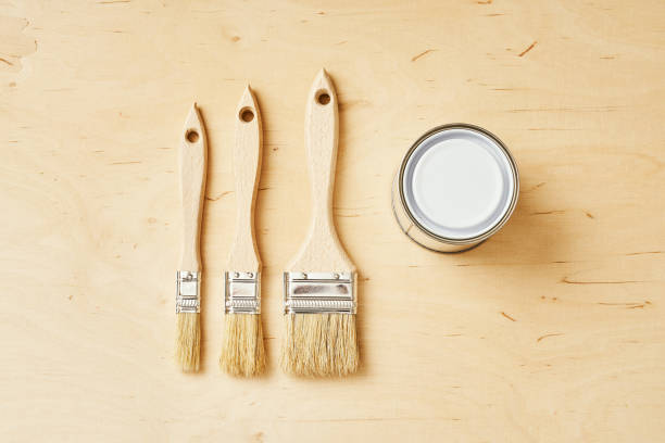 istock three brushes and a silver paint can on a wooden board 1028910210