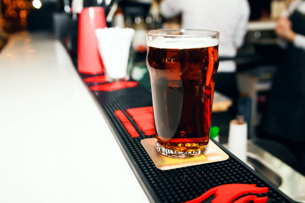 istock Dark beer in a glass on a white bar 1028913848