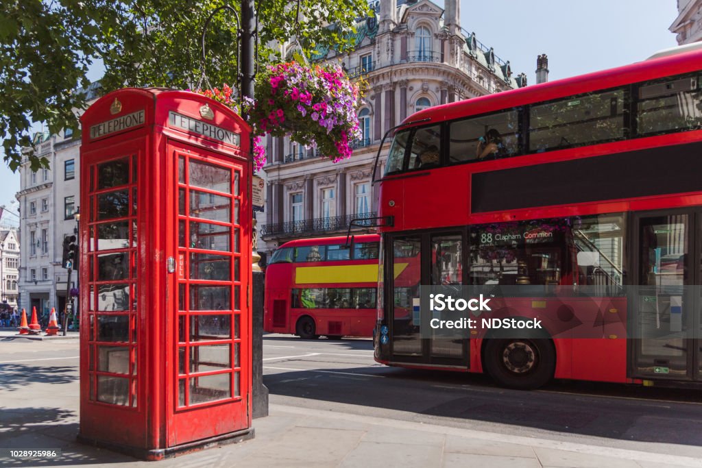 london telephone cabin and double decker bus red phone booth with colored flowers and red bus, england, great britain, london London - England Stock Photo