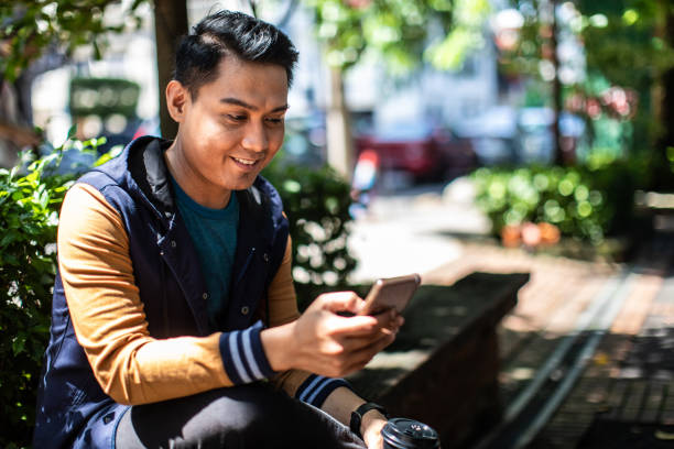 istock Young man using smart phone outdoors 1028934588