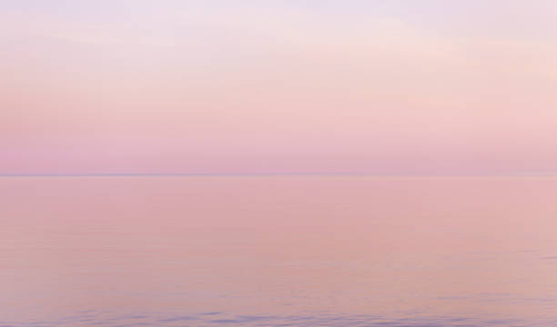 Beautiful sunset in pastel tones reflect calm water surface.