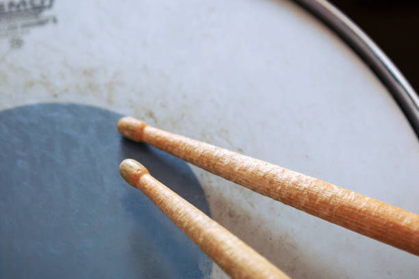 istock Pair of drumsticks lying on tom-tom drum. 1028939332