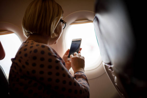 istock Woman taking a picture on an airplane 1028944922