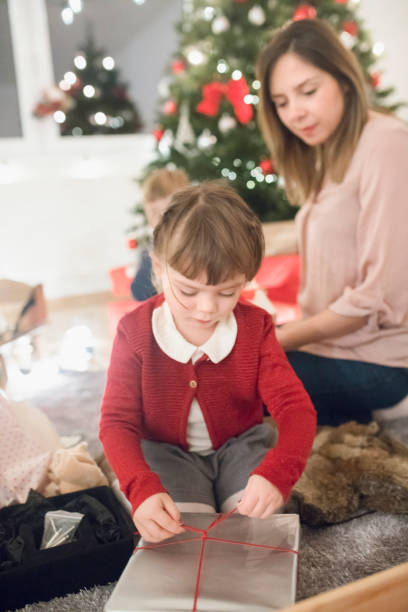 istock Girl is busy with opening her gift 1028956694