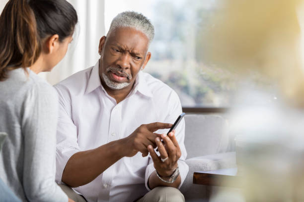 Senior man points at something on smartphone