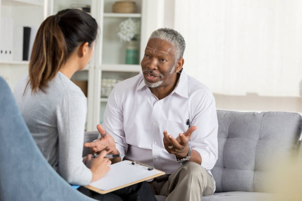 istock Senior man discusses issues with mental health professional 1028962038
