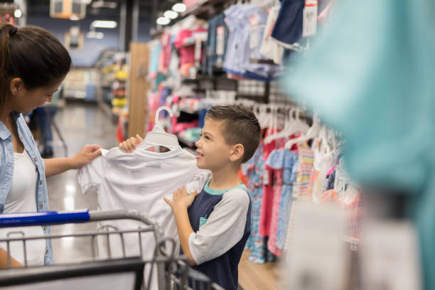 istock Little boy shops for clothing with his mom 1028962064