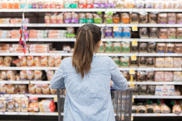 istock Woman shopping for bread in grocery store 1028962108