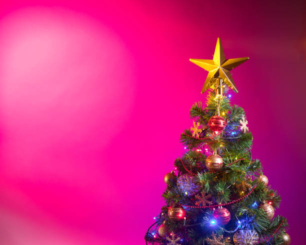 istock Christmas tree with festive lights, pink background 1028963836